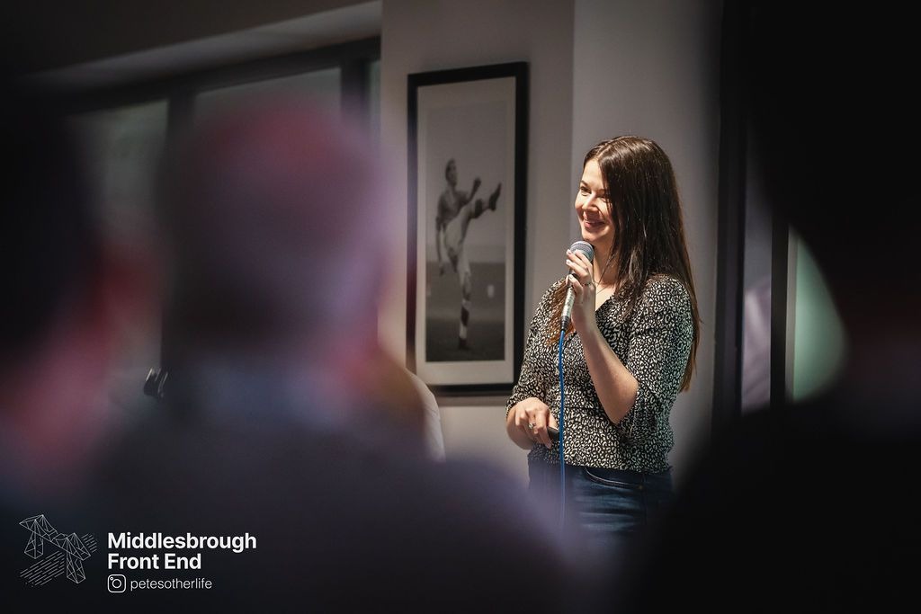 Me holding a microphone on stage at Middlesbrough FE.