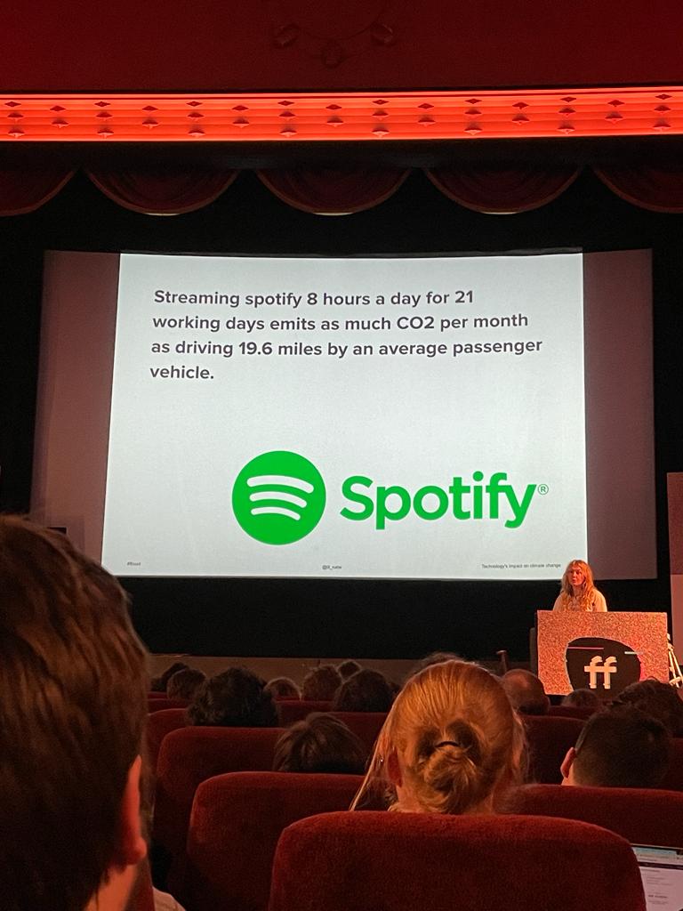 Slide saying "Streaming spotify 8 hours a day for 21 working days emits as much CO2 per month as driving 19.6 miles by an average passenger vehicle.".
